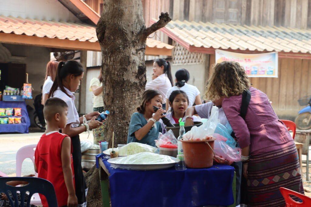 Cloé préparant, avec les enfants, de la nourriture, notamment de la salade de papaye, plat typique laotien, pour une cérémonie.